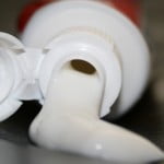 Imagem de um tubo de pasta de dente derramada.