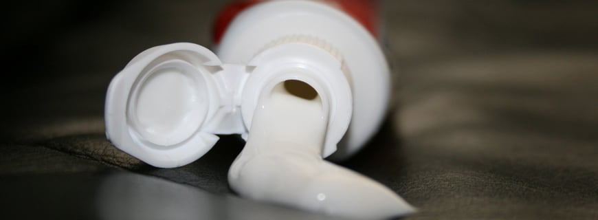 Imagem de um tubo de pasta de dente derramada.