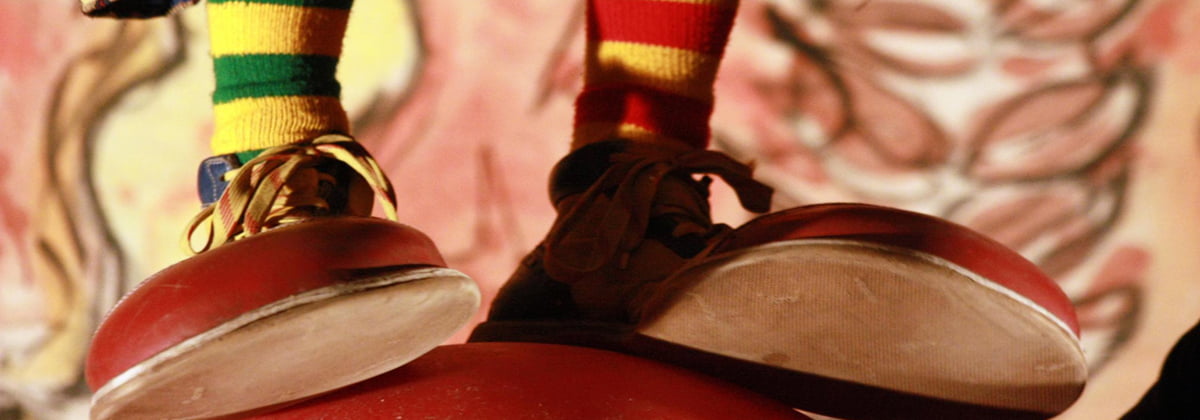 Foto de uma pessoa vestindo sapatos de palhaços.