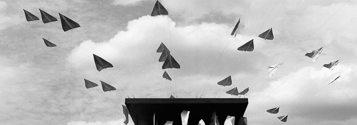 Desenho preto e branco de aviões de papel começando a voar de uma plataforma.