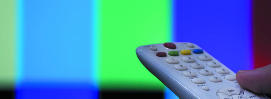 Foto de um controle apontando para uma televisão.