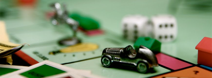 Foto do tabuleiro Monopoly, há peças posicionadas em casas do tabuleiro.