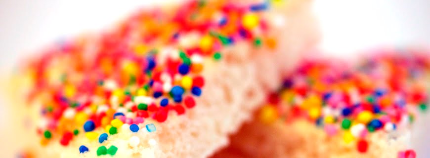 Foto de fatias de doces com confeitos multicoloridos em cima.