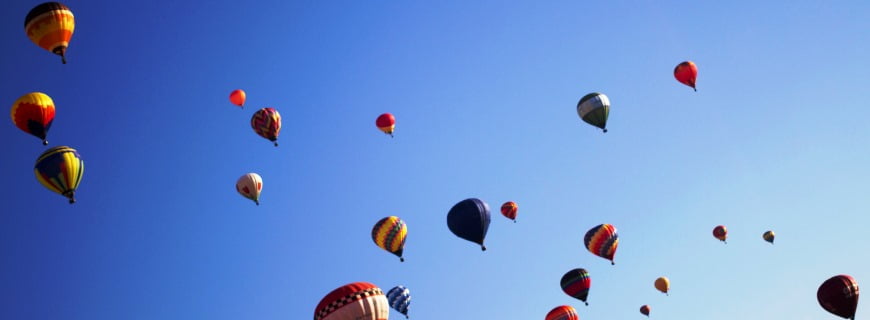 Foto de vários balões voando sobre o céu.