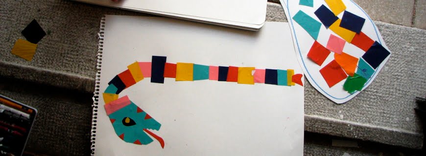 Foto de recorte de papéis multicoloridos formando uma cobra em uma folha de papel.