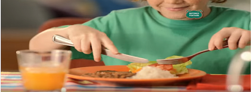 Foto de um vídeo promocional da marca Biotônico, onde um garoto de blusa verde está comendo uma refeição saudável.