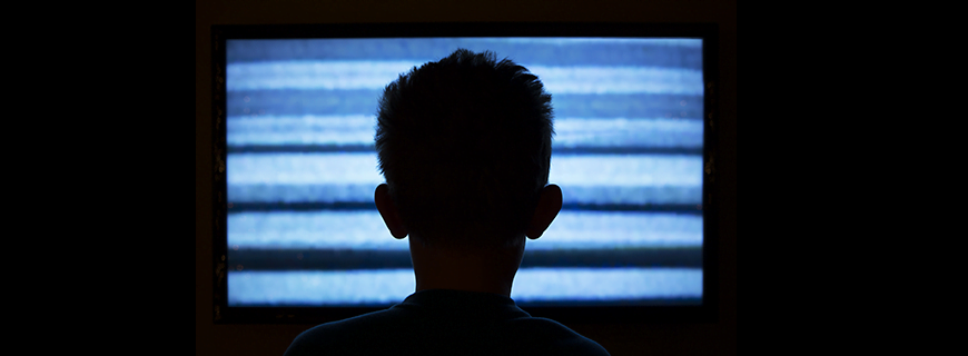 Silhueta de criança em frente a uma TV fora do ar