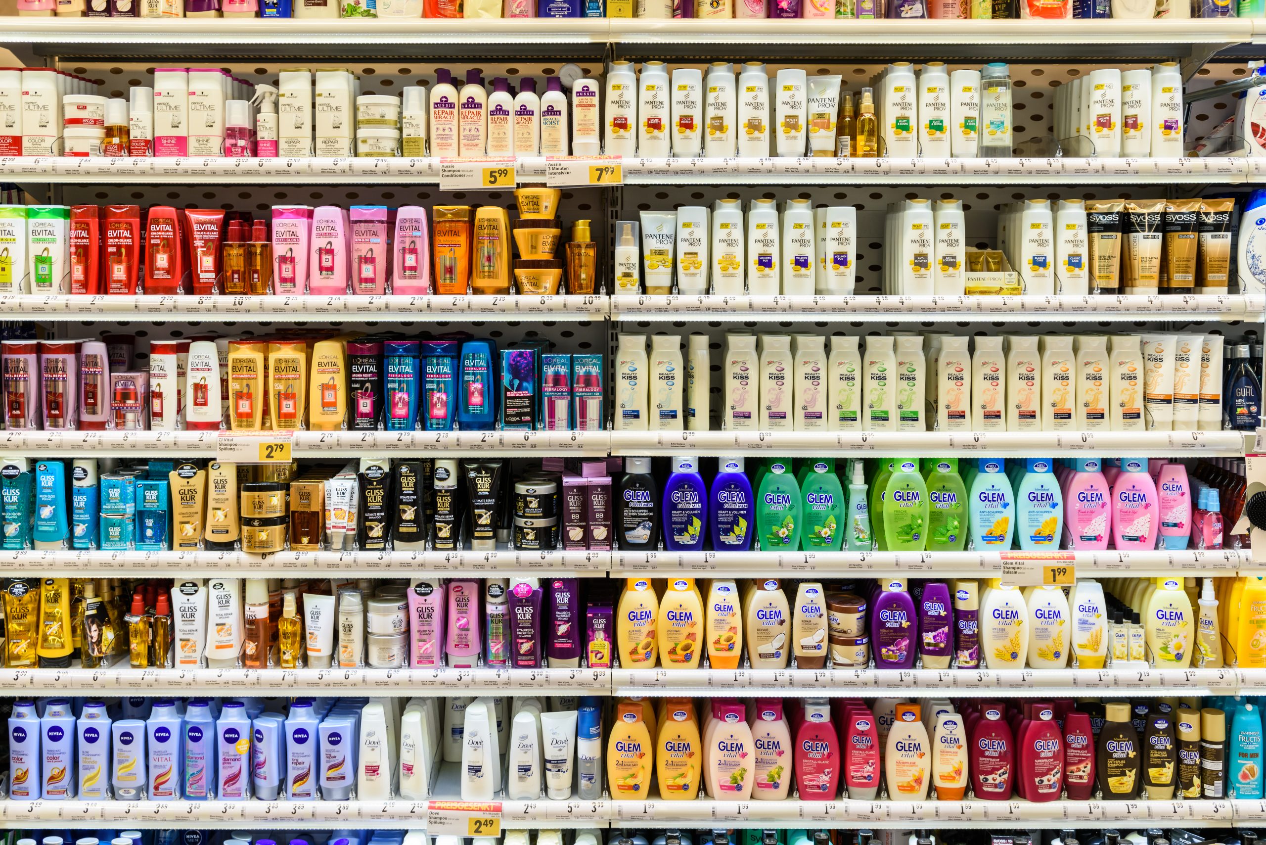 Foto de diversas prateleiras de supermercado com shampoos.