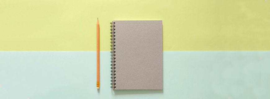 Em fundo amarelo e verde claro caderno com espiral e lápis laranja