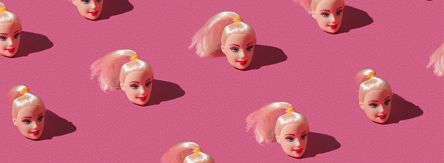 Imagem de várias cabeças de boneca sobre fundo rosa
