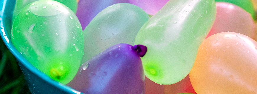 Foto de bexigas coloridas cheias d'água como foto de apoio ao texto sobre férias sem consumismo