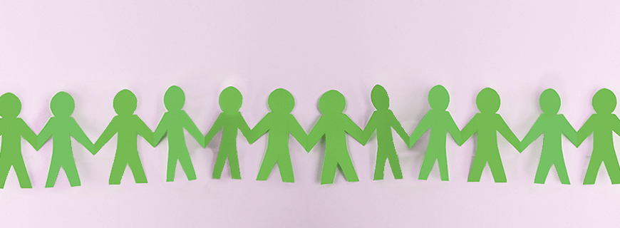 em fundo lilás, papel verde cortado em formato de pessoas dando mãos como imagem de apoio ao texto sobre obesidade infantil