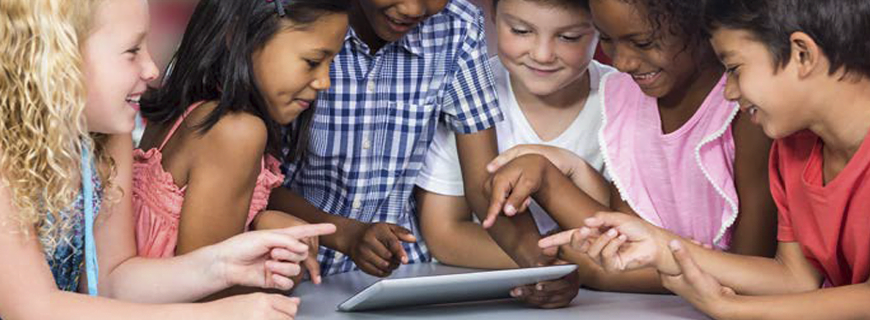 foto de diversas crianças ao redor de uma mesa mexendo em um tablet e rindo como imagem de apoio ao texto sobre realidade global a segurança de crianças e adolescentes na Internet