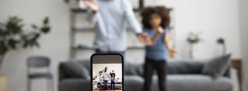 foto de um celular gravando um pai e uma filha dançando ao fundo sem foco como imagem de apoio ao texto sobre Wesley Safadão e Sharenting