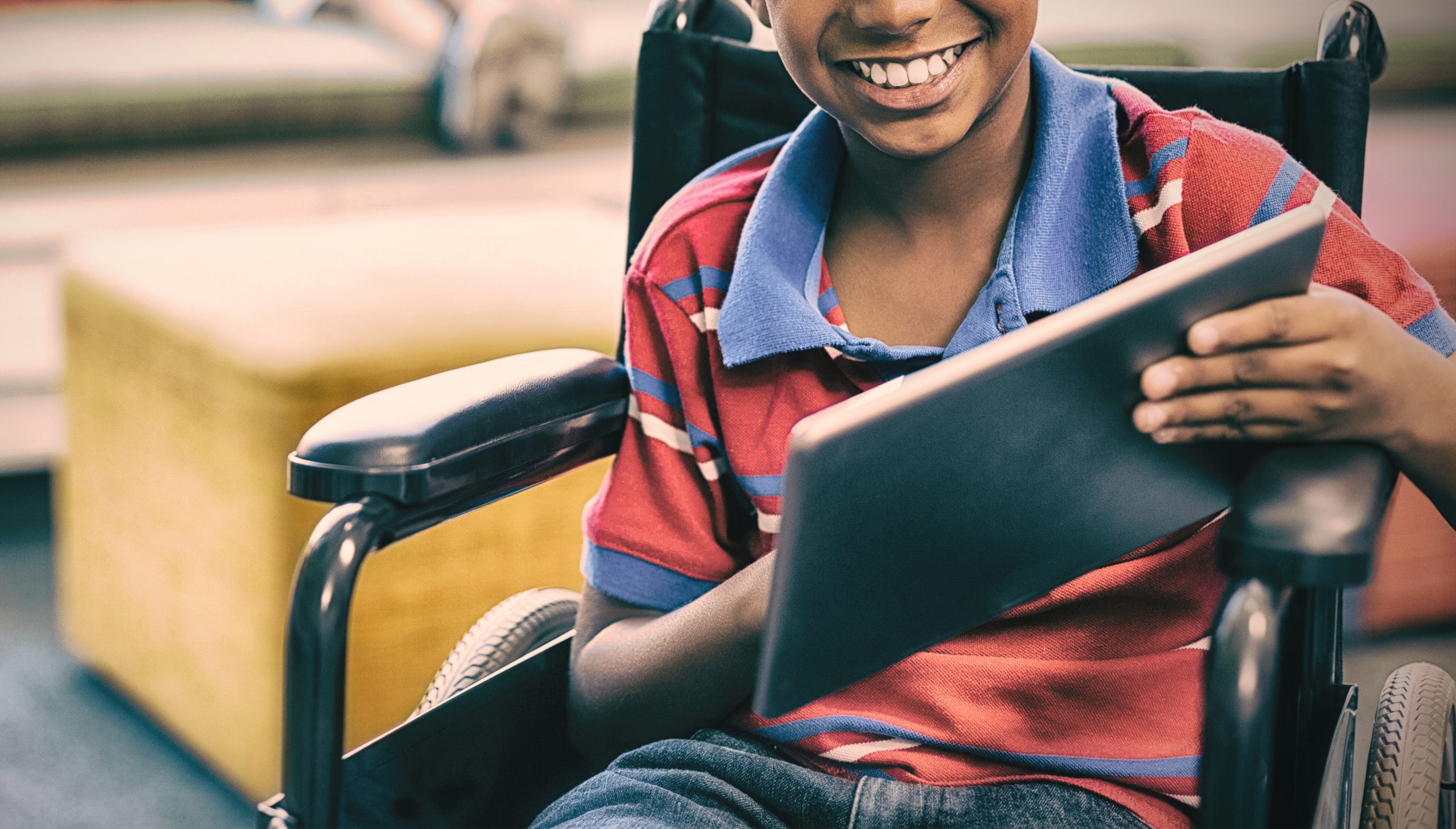 Criança sorrindo segurando um tablet