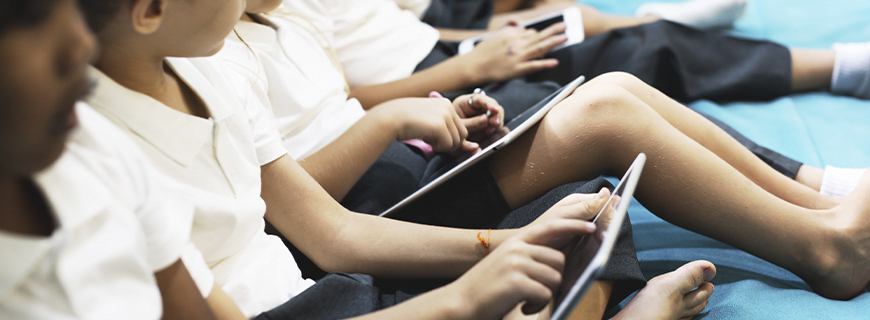 foto de diversas crianças sentadas lado a lado usando tablets e celulares como imagem de apoio ao texto sobre Clube Data e Instituto Alana